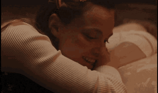 a woman in a white sweater is hugging a child in a bathtub .