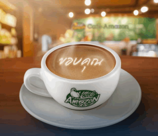 a cup of cafe amazon coffee on a saucer on a counter