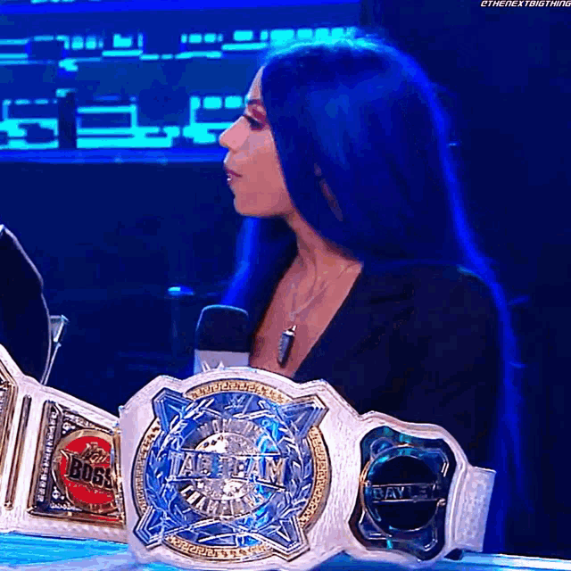 a woman with blue hair is holding a world heavyweight wrestling belt