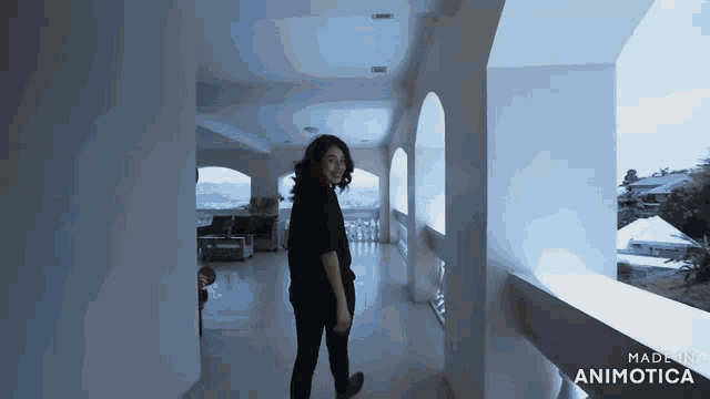 a woman is walking down a hallway with the words made in animotica on the bottom