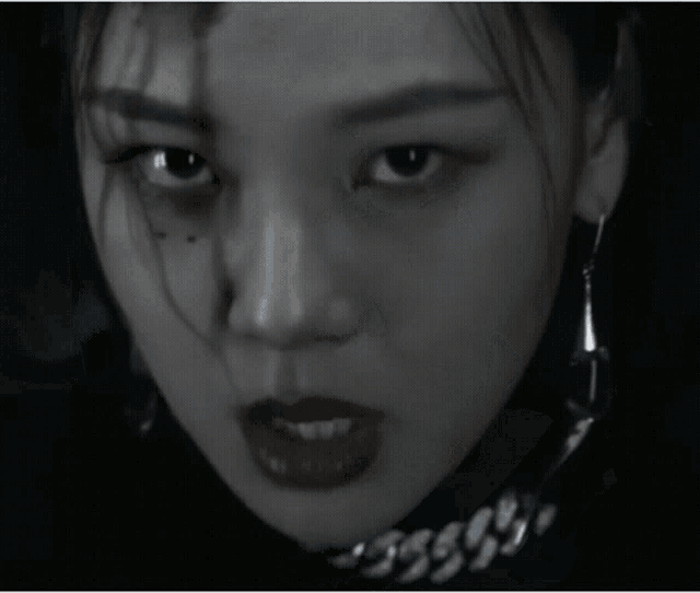 a close up of a woman 's face with black lipstick on