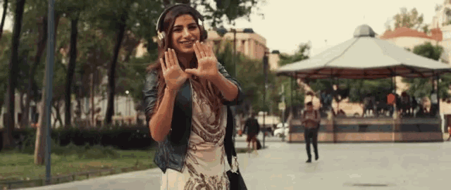 a woman wearing headphones is waving her hands