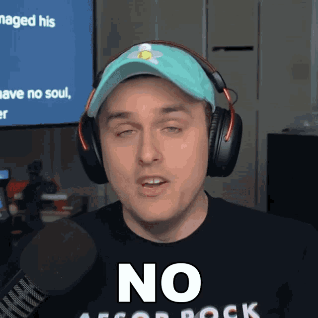 a man wearing headphones and a hat with the word no on his shirt
