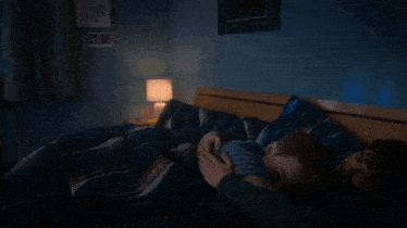 a man and a child are sleeping on a bed with a poster on the wall that says robert eakin