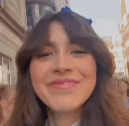 a close up of a woman 's face with a blurred background and a building in the background .