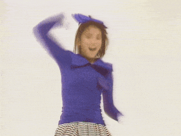 a woman wearing a blue shirt and striped skirt is dancing