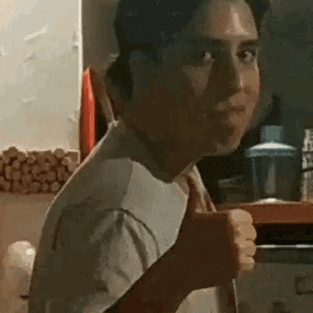 a man is making a funny face while holding a cup of coffee in his hand .