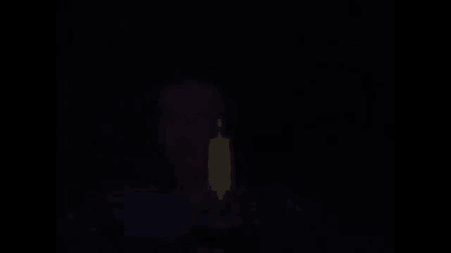 a person holding a candle in the dark