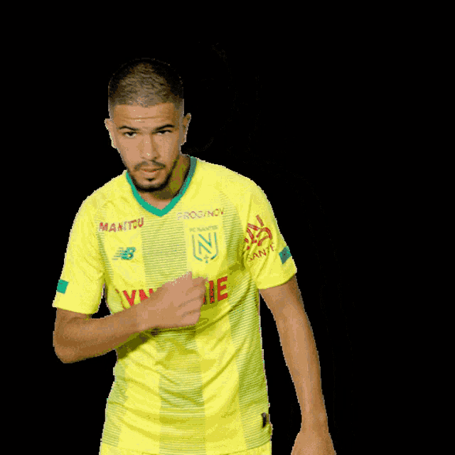 a man wearing a yellow shirt with synergie on it