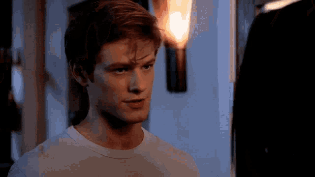 a man in a white shirt is looking at another man