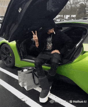 a man smoking a cigarette while sitting in the back of a green sports car