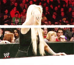 a woman in a wrestling ring with a w logo