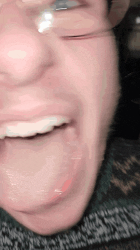 a close up of a person 's mouth with glasses