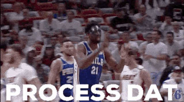 a basketball player is giving a thumbs up in front of a crowd at a basketball game .