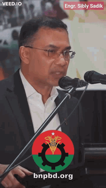 a man speaking into a microphone with a bnpbd.org logo on the bottom