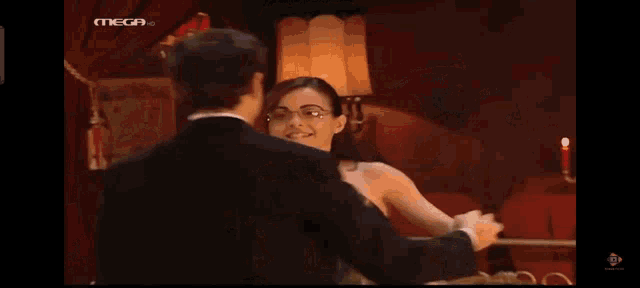 a man kissing a woman 's hand with the mega logo in the corner