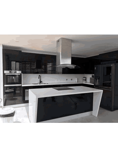 a kitchen with black cabinets and white counter tops has a large island in the middle
