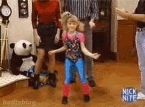 a little girl is dancing in front of a group of people on a nick nite show .