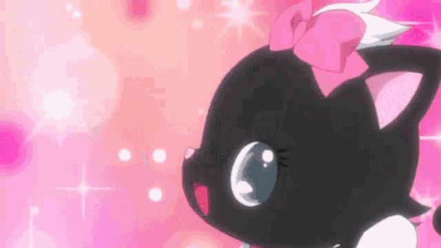 a black cat with a pink bow on its head is on a pink background .