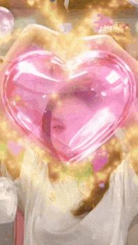 a woman is holding a pink heart shaped balloon in front of her face