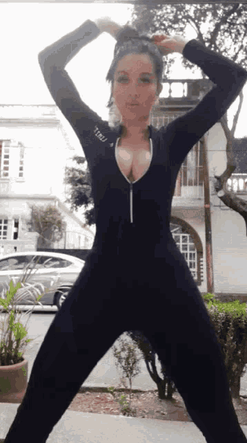a woman wearing a black jumpsuit with the letters tmblr on the sleeve