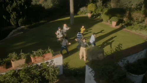 a group of people are dancing in a circle in a yard