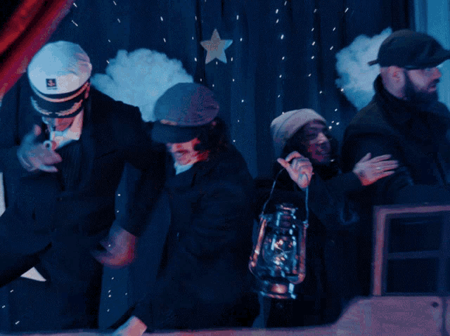 a group of people standing in front of a curtain with a star on it
