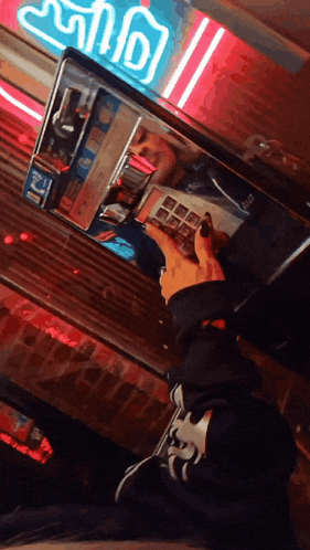 a person is looking at their reflection in a mirror in front of a neon sign that says ice cream