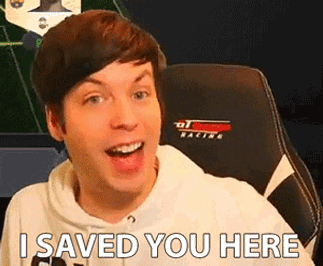 a man is sitting in a chair and smiling with the words `` i saved you here '' written on his face .