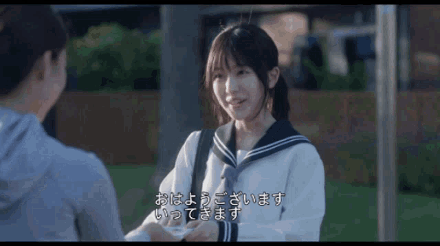 a girl in a sailor uniform is talking to another girl in another language