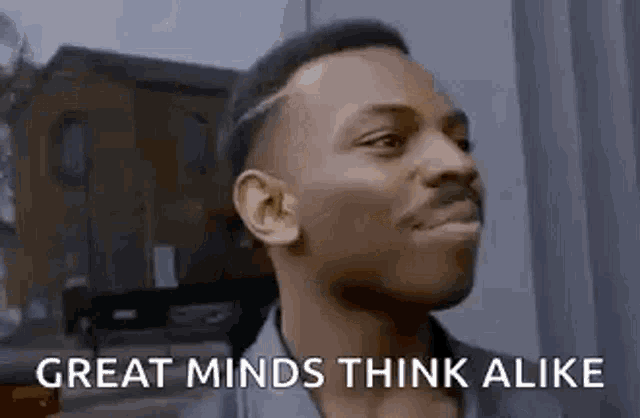 a man is making a funny face and saying `` great minds think alike '' while looking up .