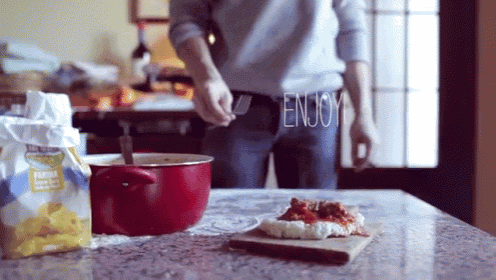 a man is preparing food and the word enjoy is written on his pants