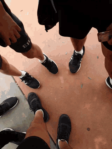 a group of people are standing in a circle with one wearing shorts that say hs