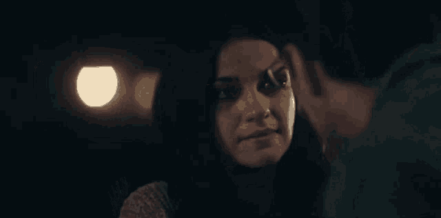 a man and a woman are looking into each other 's eyes in the dark .