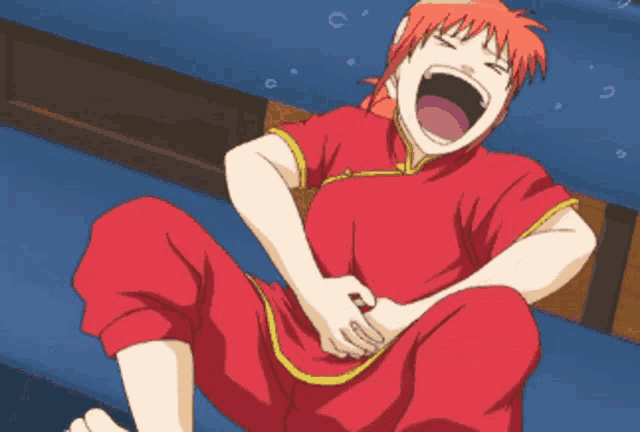 a person in a red shirt is laughing and holding their belly