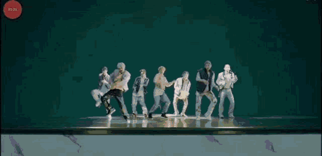 a group of young men are dancing together on a stage .