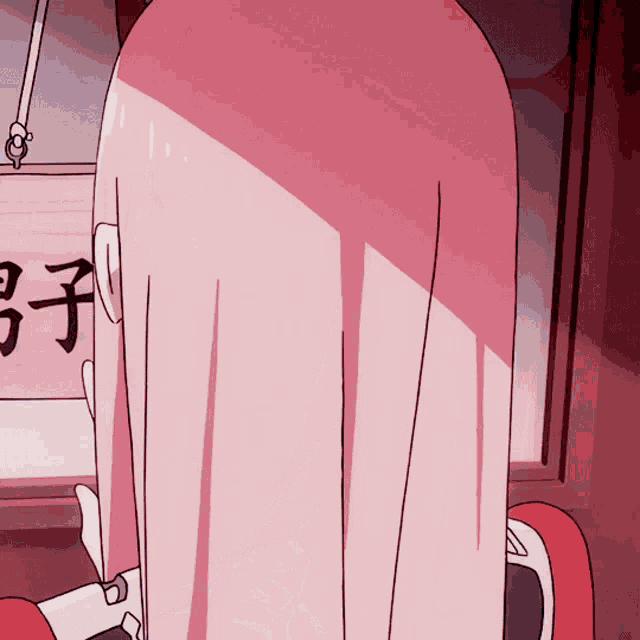 a girl with pink hair is standing in front of a sign with chinese writing