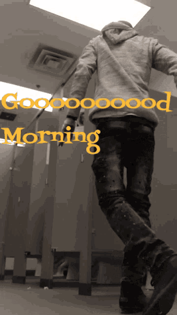 a man in a hoodie is walking in a bathroom with the words good morning written on it