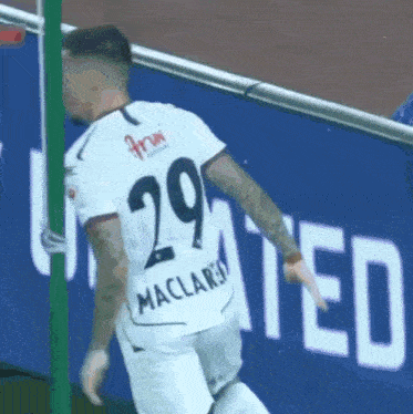 a soccer player wearing a white jersey with the number 29 on the back