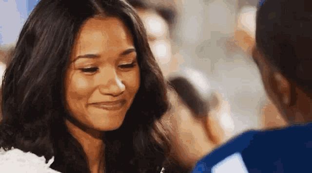 a woman is smiling while looking at a man .