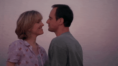 a man and a woman are looking at each other and smiling