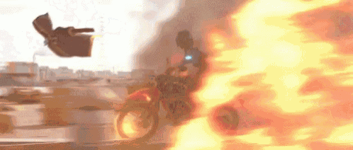 a man is riding a motorcycle next to a fireball .