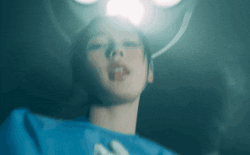a blurry picture of a woman in an operating room with a light shining on her face