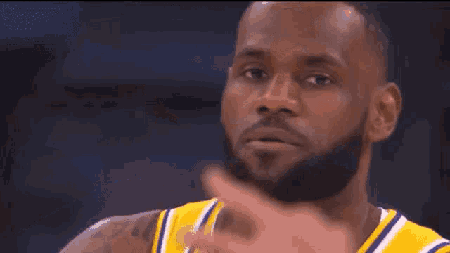 a man with a beard is wearing a yellow and purple shirt