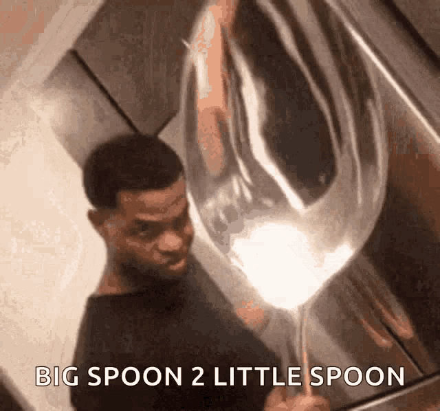 a man is holding a large spoon with the words big spoon 2 little spoon below him