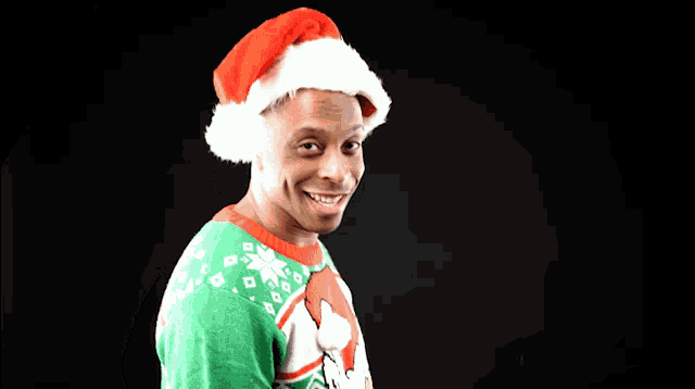 a man wearing a santa hat and sweater smiles