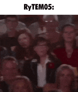 a blurry picture of a crowd of people sitting in a theater with the words rytem05 written above them .