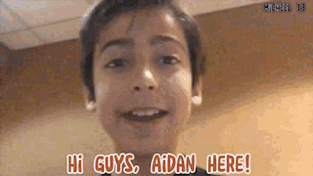 a young boy says hi guys aidan here in front of his face