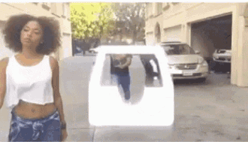 a woman in a white tank top is standing in front of a garage with a car in the background .
