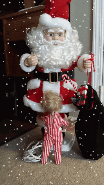 a statue of santa claus is holding a candy cane and a bag of presents